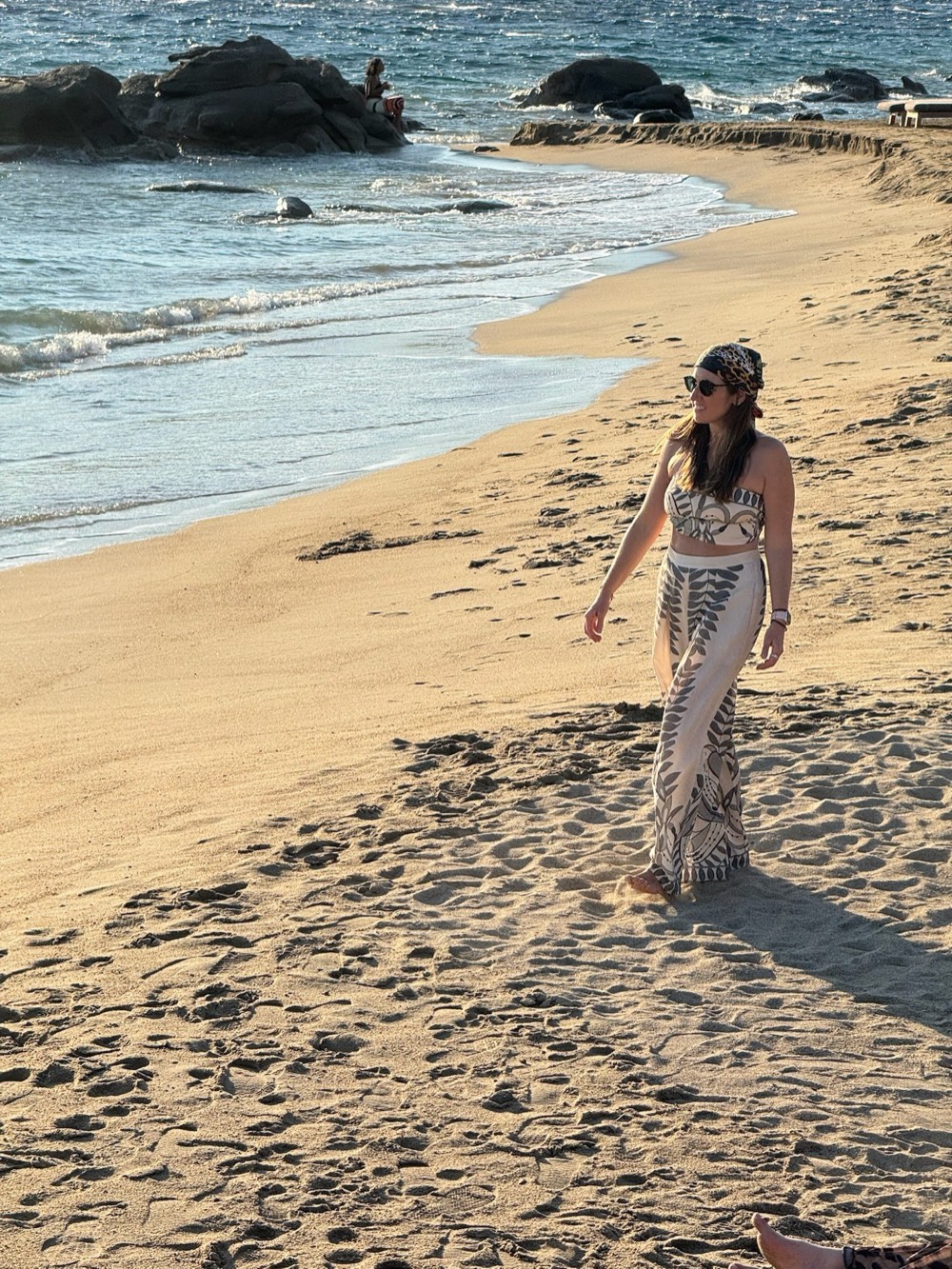 Jenn Smukler walking along a sunlit beach